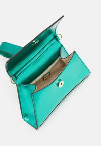 Turquoise metallic handbag with a folded design, featuring a gold snap closure, black trim, and a single adjustable strap.