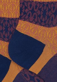 Calzini multicolori con intricati motivi in blu navy, viola e oro; sezioni lavorate a maglia creano un'appeal visivo variegato.