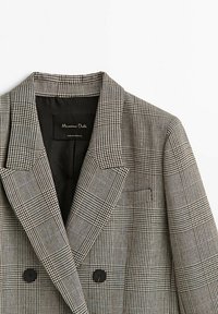 Blazer croisé noir et blanc à carreaux, avec de larges revers et des boutons noirs, étiqueté Massimo Dutti, fabriqué au Portugal.
