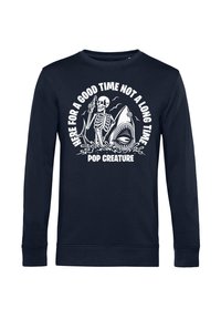 Sudadera de manga larga de color navy hecha de una mezcla de algodón, con un diseño que presenta un esqueleto sosteniendo una bebida, un tiburón y texto en color blanco.