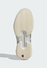 Sneaker sula med en texturerad gummiyta med fiskbensmönster, delad design och en ljusgrå och vit färgsättning.