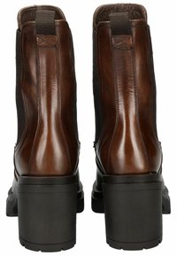 Bottines en cuir marron avec panneaux latéraux élastiques, bout arrondi et talons épais noirs. Texture lisse avec un léger éclat.