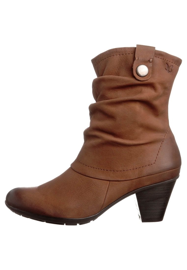 Bota de tobillo de cuero marrón con caña flexible, puntera redonda y tacón redondeado. Cuenta con un adorno metálico de broche y detalles de costura.