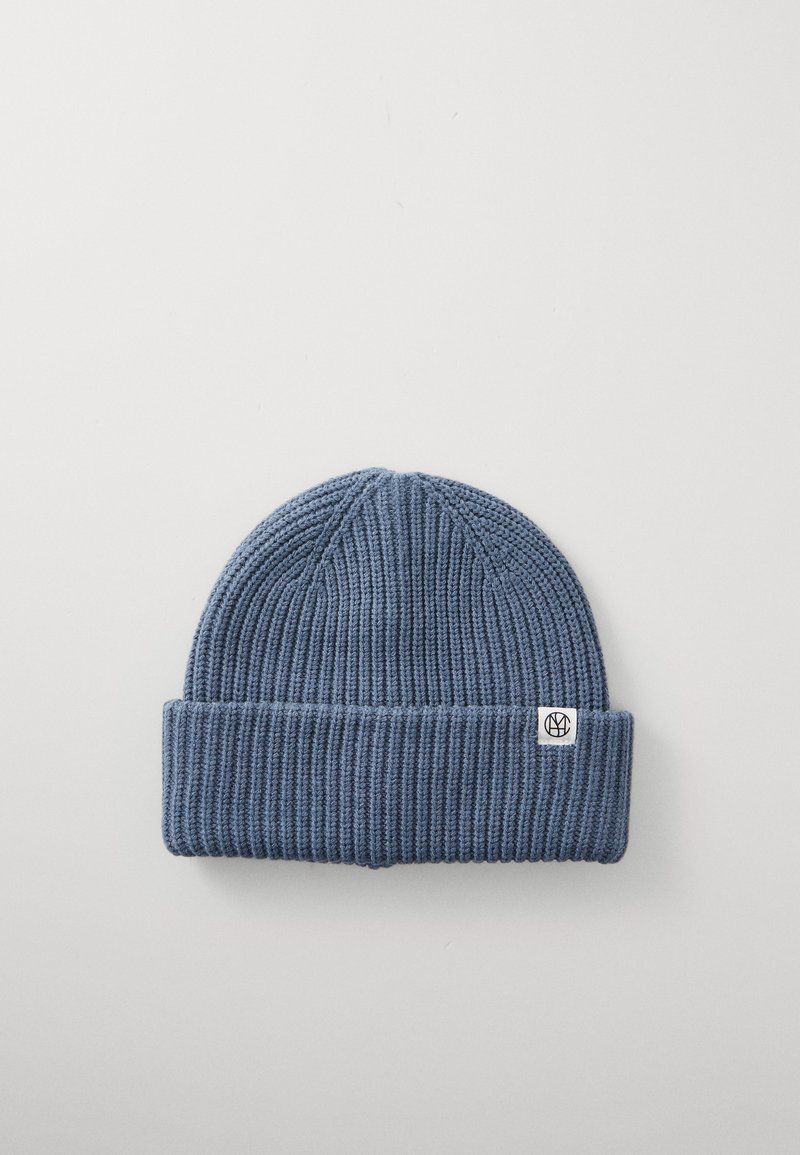 Gebreide beanie in donkerblauw met een geribbelde textuur en een omgeslagen rand. Heeft een klein logopatch aan de zijkant.