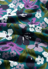 Floral fabric with a teal background featuring various flowers in purple, white, and green. Soft texture with visible creases.