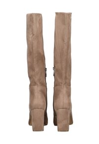 Et par høje beige suedestøvler med blockhæle og lynlåse i siden, vist fra ryggen.