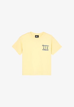 Jasnożółty t-shirt z krótkim rękawem z małą kreskówką przedstawiającą trzy osoby trzymające deskę surfingową oraz logo Quiksilver na lewej piersi.