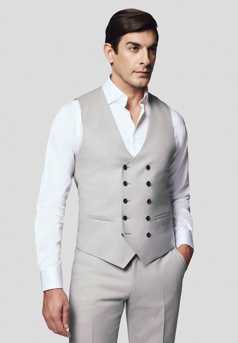 Jasnoszary, podwójnie zapinany kamizelka z czarnymi guzikami, noszona na białej koszuli; gładka tkanina o dopasowanym kroju; elegancki i nowoczesny design.