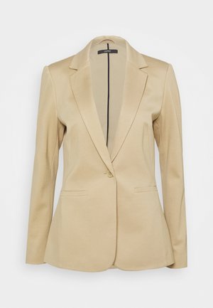 Beige enkeltknappet blazer med hakrevers, lange ærmer og to forlommer med paspolerede åbninger, skræddersyet pasform, vist på en ensfarvet baggrund.