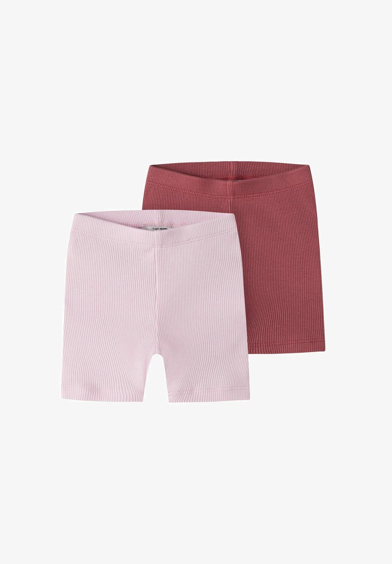 Deux paires de shorts en maille côtelée, une rose pâle et une rose foncé, posées à plat sur un fond blanc.