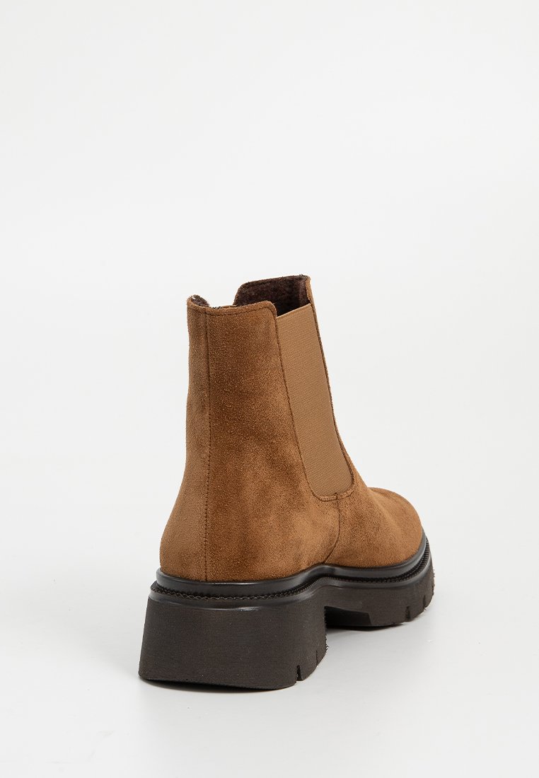 Brauner Wildleder-Stiefelette mit elastischem Seitenpanel und dickem schwarzem Blockabsatz, von hinten und seitlich auf weißem Hintergrund gezeigt.