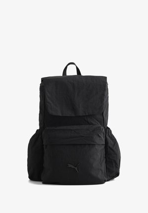 Sac à dos en tissu noir avec rabat supérieur, pochette zippée à l'avant, poches latérales et petit logo Puma sur la pochette avant.