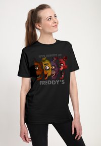 Czarna bawełniana koszulka z kolorowymi postaciami z „Five Nights at Freddy's” nadrukowanymi na przodzie wraz z wyrazistym, stylizowanym tekstem.