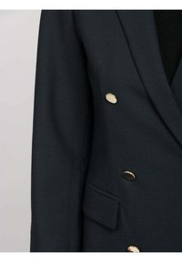 Blazer blu scuro realizzato in tessuto texturizzato, con bottoni dorati doppi e una tasca singola sul davanti.