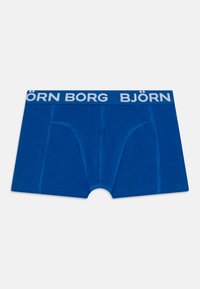 Blue boxer shorts made of soft fabric with a white "BJÖRN BORG" logo waistband. Features two front pockets and stitched detailing.