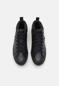 Tenisi negri dintr-o combinație de piele netedă și țesătură texturată. Prezintă un design de tip high-top, șireturi ample și talpă din cauciuc.