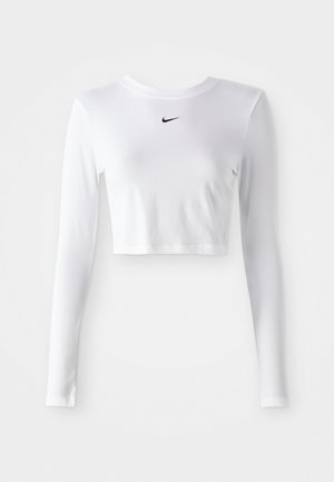 Long-sleeve, cropped athletic top in white fabric, features a black Nike logo on the chest, smooth texture, and fitted design.