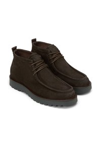 Bottines en daim marron avec des lacets, présentant un dessus texturé, un col rembourré et une semelle en caoutchouc grise contrastante, améliorant la durabilité et l'adhérence.