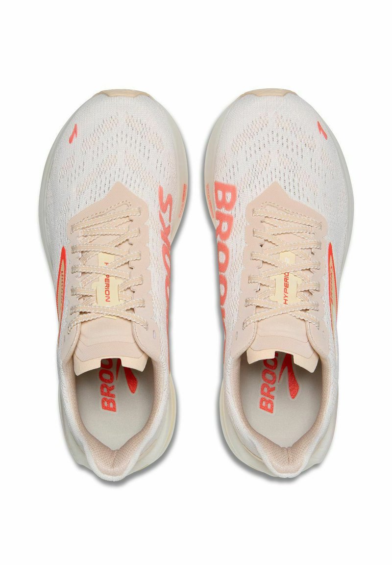 Beżowe buty biegowe z teksturowaną siateczką na cholewce, pomarańczowe logo "BROOKS" po bokach oraz lekko amortyzowana podeszwa. Posiada płaskie sznurówki.