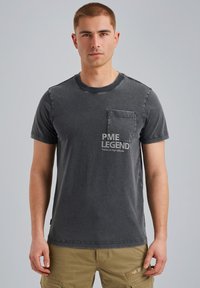 Camiseta de algodón gris con cuello redondo, mangas cortas y un bolsillo en el pecho izquierdo que presenta "PME LEGEND" impreso en gris claro.