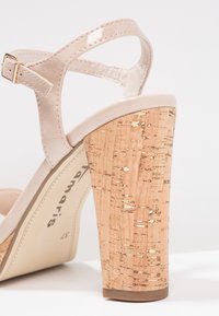 Sandale en daim beige avec bride de cheville ajustable et épais talon bloc en liège avec des détails pailletés dorés.