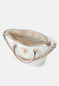 Witte gewatteerde shopper met gouden kettingaccenten, roze handvatten en een ritsvak. Het interieur heeft een beige voering met logopatroon.