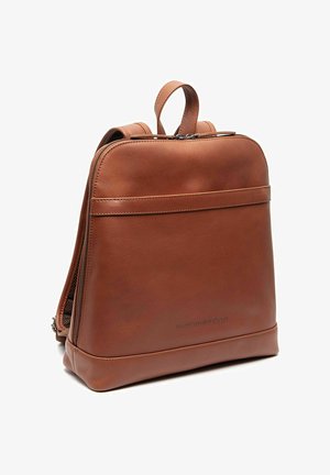 Sac à dos en cuir marron avec poignée supérieure, bretelles d'épaule jumelles réglables et poche avant zippée, debout sur fond blanc.