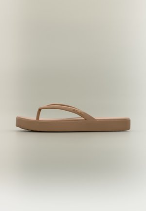 Une sandale Crocs marron simple avec une bride simple et une semelle légèrement surélevée sur un fond neutre.