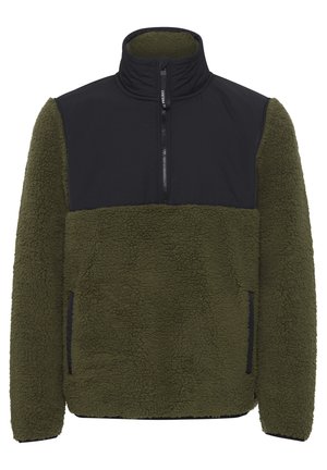 Alyvuogių žalia vilnos pūkinė striukė su juodu nailoniniu krūtinės paneliu. Turinti aukštą apykaklę, pusiau užtrauktuką ir šonines kišenes.