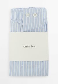 Vêtement rayé bleu clair plié avec une ceinture élastique et deux boutons blancs, sécurisé par une étiquette blanche simple affichant le nom de la marque.