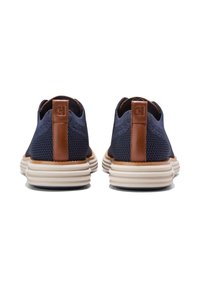 Námořnické modré síťové boty s hnědými koženými akcenty, vybavené polstrovaným límcem a bílou, texturovanou podrážkou s vrstvenými designovými prvky.