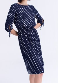 Námořnické šaty s puntíky a rukávy do loktů, s úzkým pasem a zavazováním na rukávech. Lehce materiál a délka ke kolenům.