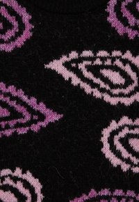 Adīta džemperis ar melnu pamatu un rozā un purpura lapu rakstiem. Audumam ir mīksta tekstūra un ribota apkakle.