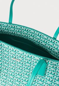 Türkizkék válltáska DKNY logómintával, elegáns fogantyúkkal és cipzáras rekesszel, sima bőr belsővel.