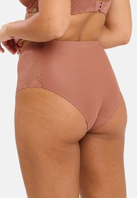 Culotte taille haute marron avec un motif géométrique texturé. Fabriquée en tissu lisse, présentant des bords nets et un subtil éclat.