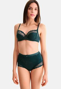 Ensemble de lingerie en dentelle vert foncé comprenant un soutien-gorge balconnet avec des bordures en dentelle et un slip taille haute avec des accents en dentelle et une bande élastique lisse.