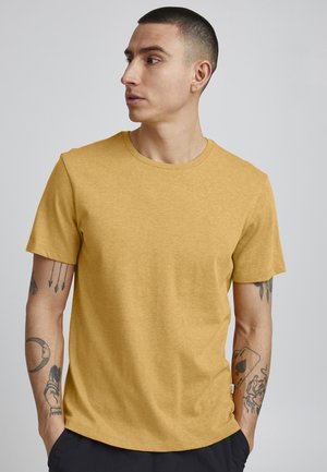 Mustard yellow t-shirt made of soft cotton, featuring a classic crew neck, short sleeves, and a relaxed fit. Subtle logo detail on the chest.
