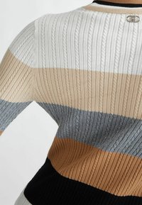 Maglione lavorato a maglia con strisce orizzontali in bianco, beige, grigio, marrone e nero, con texture a coste e un dettaglio di chiusura metallica sul retro.