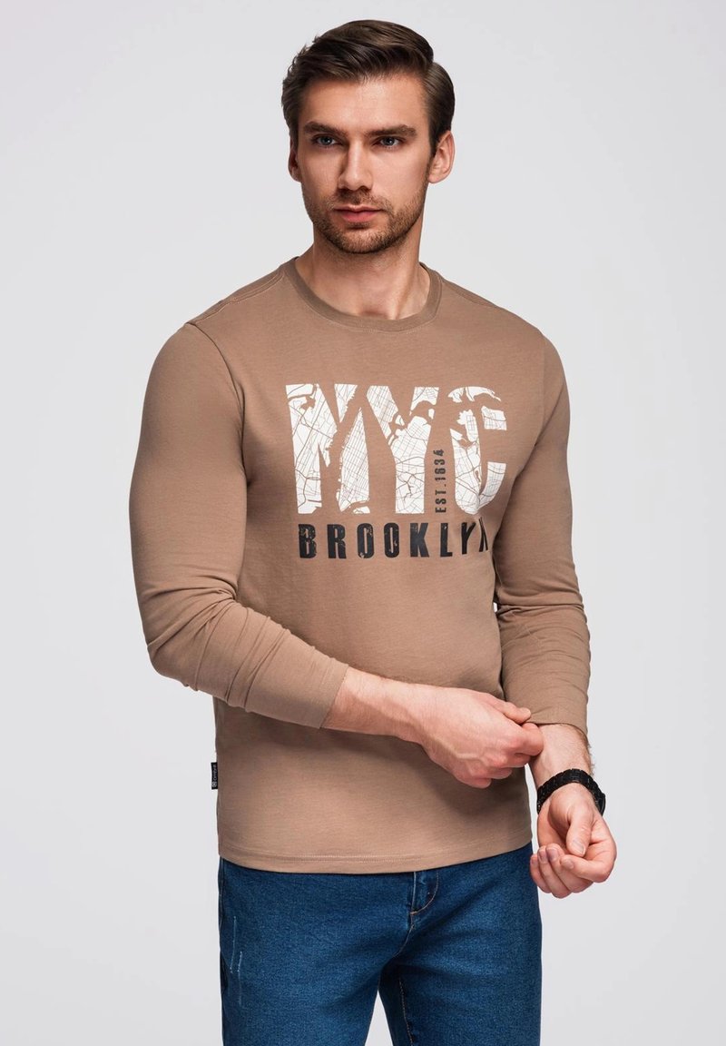 Helles braunes Langarm-T-Shirt mit einem großen grafischen Druck "NYC BROOKLYN" in Schwarz und Weiß. Hergestellt aus weichem Baumwollstoff.