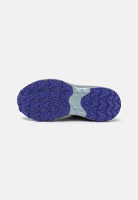 Sola do sapato de trail running com uma base cinza e piso de borracha roxa. Apresenta cravos multidireccionais para tração e uma entressola texturizada.