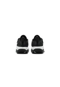 Las zapatillas deportivas negras presentan una parte superior de textil suave, una media suela blanca en contraste y una suela exterior de goma negra texturizada con surcos para una mayor tracción.