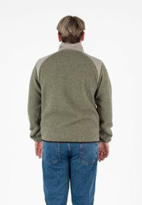 Giacca in pile di colore verde oliva con accenti beige chiaro sulle spalle. Caratterizzata da un alto colletto e polsini elasticizzati. Tessuto morbido. Adatta per un abbigliamento informale.