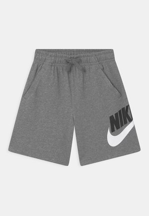 Szare spodenki Nike z elastycznym pasem, sznurkiem do regulacji, bocznymi kieszeniami oraz dużym czarno-białym logo Nike na prawej nogawce.