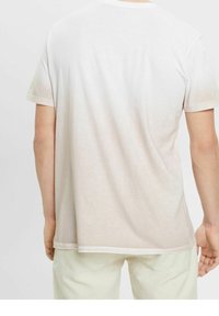 T-shirt di colore chiaro a maniche corte, con una morbida sfumatura sfumata dal bianco al beige. Texture liscia con un design classico a girocollo.