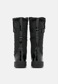 Musta talvisaappaat, joissa on turkisreunus, kiiltävät korkolaput, sivunauhat jateksturoitu pohja, nähtynä takaa harmaalla taustalla.