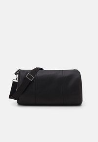 Svart läder gymväska med en texturerad yta, cylindrisk form och en justerbar tygaxelrem med en silvermetallspänne.