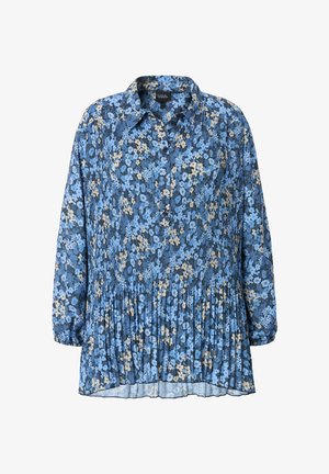 Blouse florale bleue à manches longues, texture plissée, col et fermeture à boutons. Présente des motifs floraux bleu clair, marine et crème.