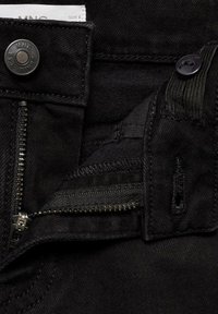 Svarta denimjeans har en metallknappstängning, dragkedja och kontrasterande sömmar. Tyget har en slät yta med minimalt med detaljer.