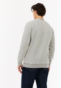 Grijze sweatshirt gemaakt van zachte stof, met lange mouwen, ribgebreide manchetten en een ronde hals. Beschikt over een eenvoudig, ongecompliceerd ontwerp.