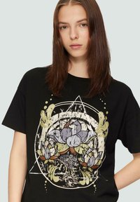 Schwarzes Baumwoll-T-Shirt mit einem grafischen Design aus Blumen und abstrakten Formen in den Farben Weiß, Grün und Lila. Kurze Ärmel, lockere Passform.
